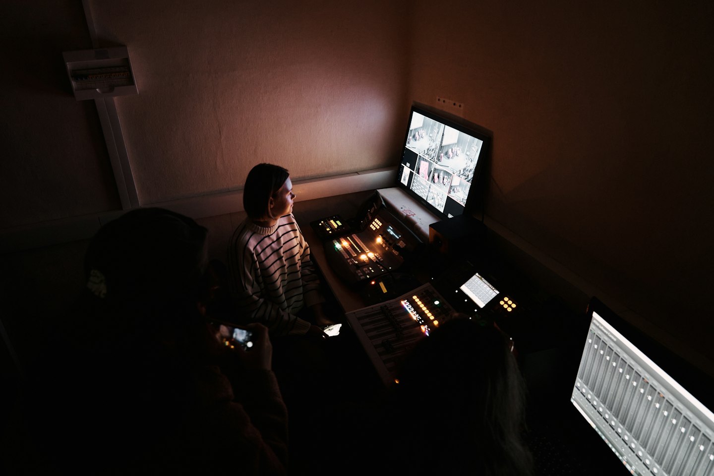 Persone che lavorano in una sala di controllo tecnica affollata di notte.