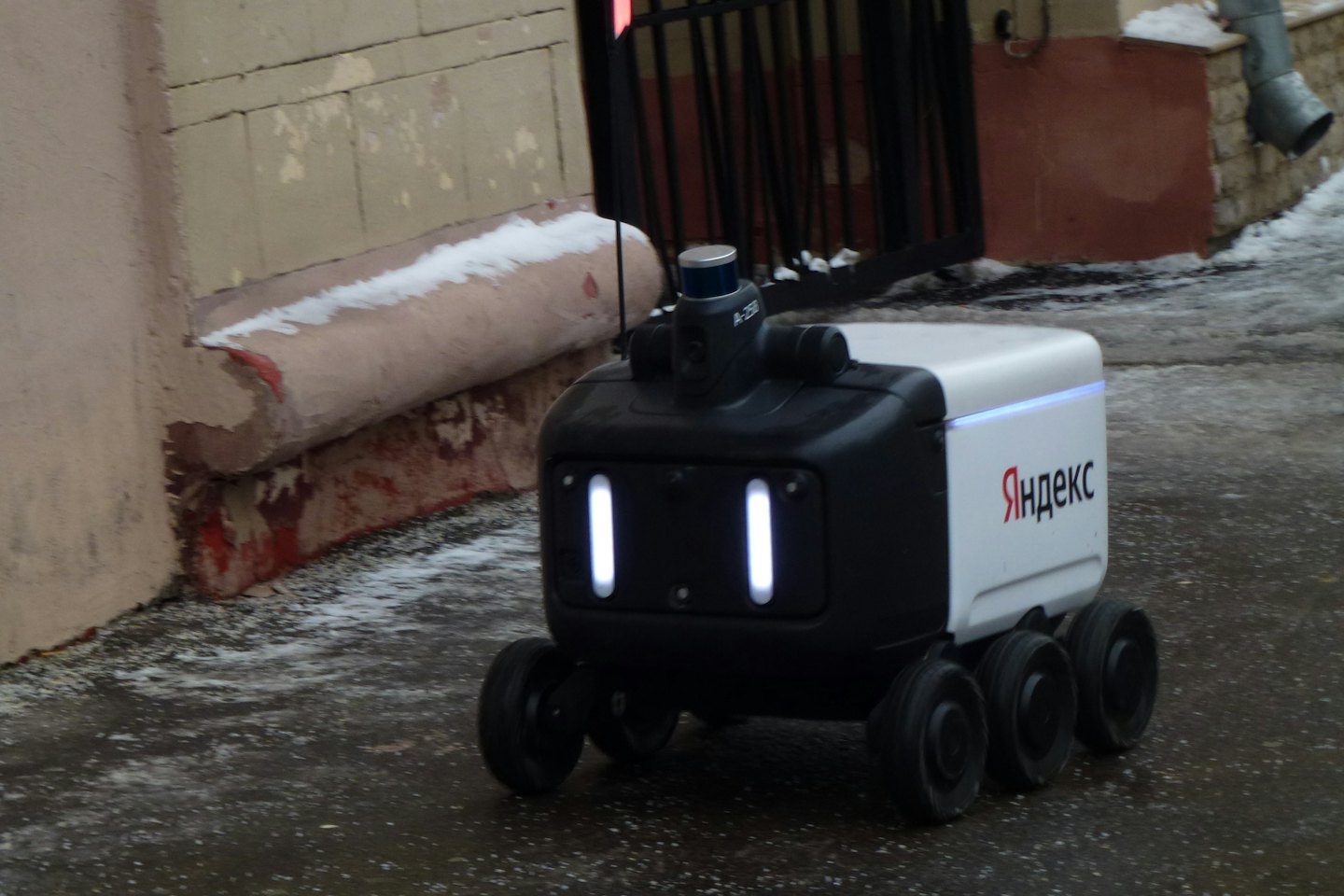 Un robot di consegna autonomo attraversa un marciapiede ghiacciato.